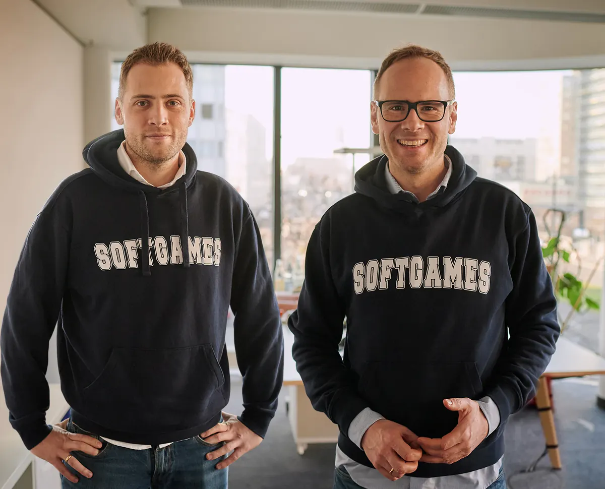 The SOFTGAMES founders, brothers André and Alexander Krug, standing in SOFTGAMES hoodies in the office